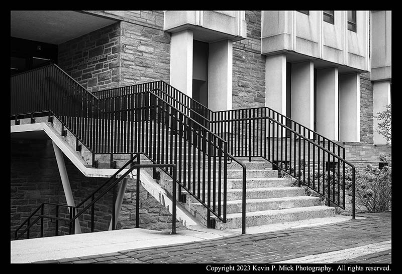 BW photograph of steps and railing leading into a library.