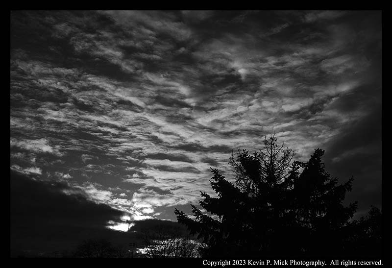 BW photograph of the sun rising on a blustery day.